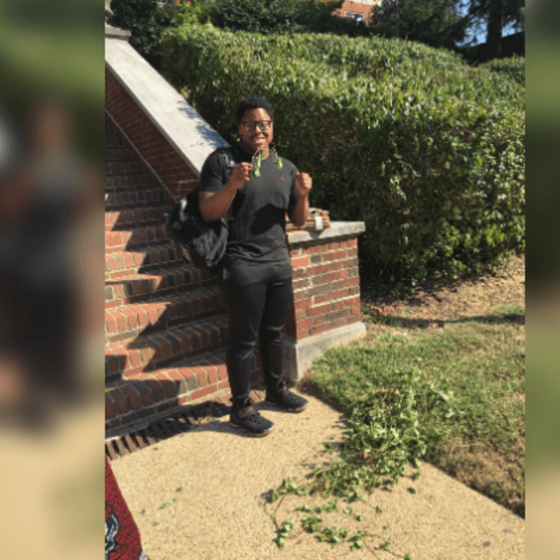 ES Student Holding Grass on the Lower Yard