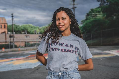 Female college student is facing camera wearing a Howard University shirt.