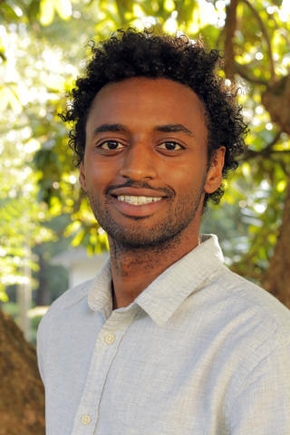 James Ousman Cheek, Environmental Studies graduate smiles into the camera.