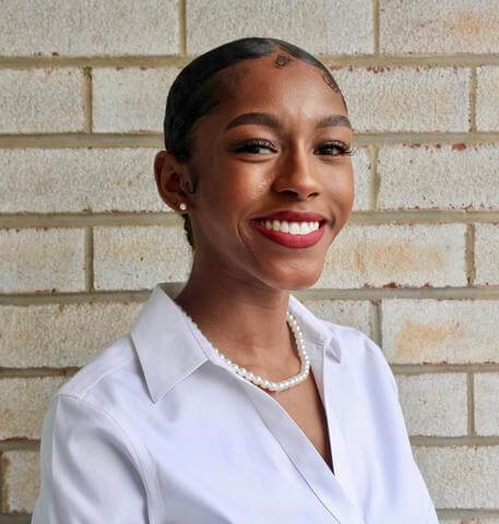 Mya Wells looks into the camera and smiles.